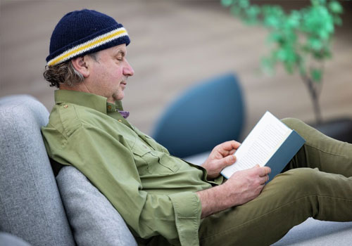 Ein Gast liest ein Buch in der Explorer-Lounge von MS Fridtjof Nansen.